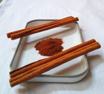 Cinnamon Water for Effective Weight Loss Recipe - Plattershare - Recipes, food stories and food lovers Cinnamon sticks with ground cinnamon on a white tray, ready for cooking or baking.