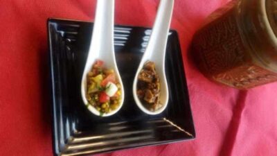 Tangy Twisted Moth Salad: A Refreshing Take on a Classic Indian Chaat - Plattershare - Recipes, food stories and food lovers Close-up of Tangy Twisted Moth Salad served in white spoons on a black plate.
