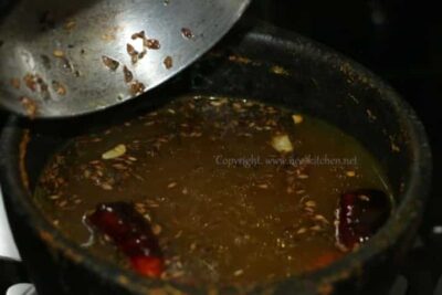 Revitalizing Wheatgrass Rasam: A Tangy South Indian Soup - Plattershare - Recipes, food stories and food lovers Wheatgrass Rasam in a traditional South Indian pot, showcasing its tangy, flavorful broth with spice.