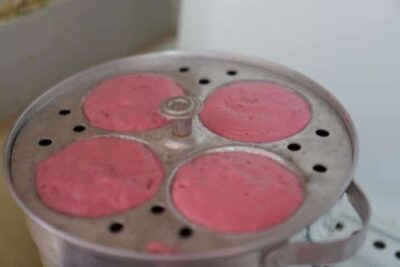 Vibrant Beetroot Rawa Idli: A Healthy and Delicious South Indian Breakfast - Plattershare - Recipes, food stories and food lovers Idli steamer with pink beetroot batter for healthy South Indian breakfast.