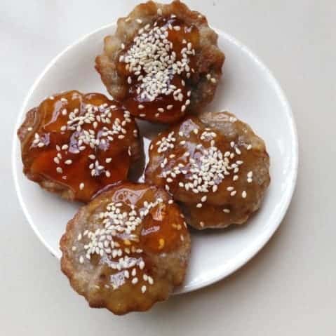 Bengali Palm Sugar Muffins: A Taste of Autumn - Plattershare - Recipes, food stories and food lovers Bengali Palm Sugar Muffins on a white plate with caramel glaze and sesame seeds.