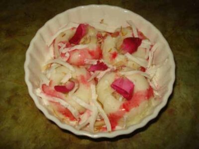 Creamy & Delicious Paneer Kulfi: A Refreshing Indian Treat - Plattershare - Recipes, food stories and food lovers Paneer Kulfi in a bowl, showcasing a creamy Indian dessert garnished with rose petals and shredded c.