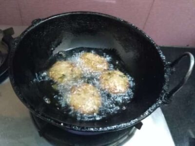 Crispy Instant Masal Vada: A Quick & Flavorful Snack - Plattershare - Recipes, food stories and food lovers Crispy Masal Vadas frying in hot oil in a wok.