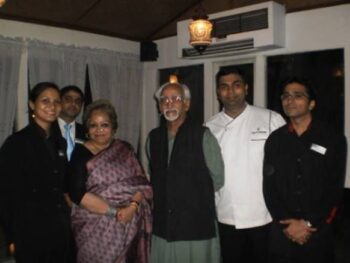 Group of people at a dinner event, smiling and posing together indoors.