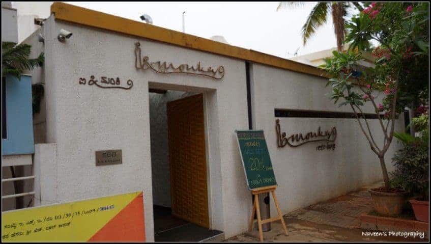 Mother's Day Celebration At I & Monkey, Indiranagar - Plattershare - Recipes, food stories and food lovers Cozy outdoor restaurant entrance with welcoming signage and lush greenery in the background.