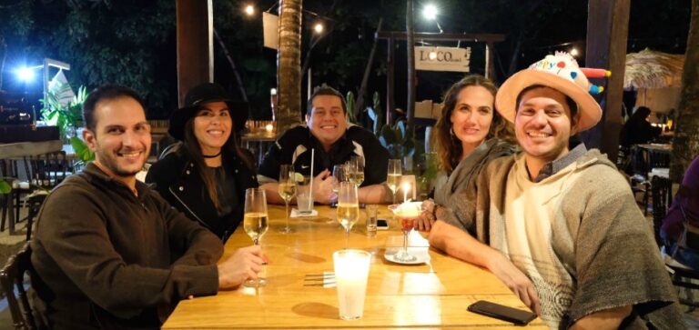 A Foodie's Complete Restaurant Guide To Tulum - Plattershare - Recipes, food stories and food lovers People celebrating at a dinner table with drinks and candles outdoors at night.