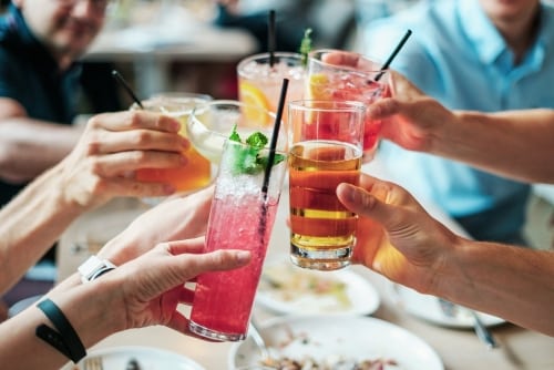 Proven Hacks To Turn Any Restaurant Into An Instagram Powerhouse - Plattershare - Recipes, food stories and food lovers Cheerful group raising colorful cocktails in celebration at a lively outdoor gathering.