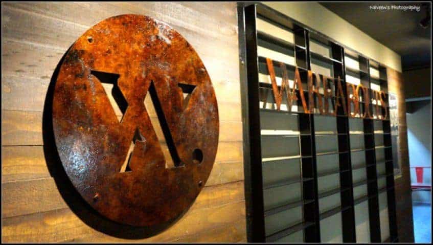 Food Bloggers Association Bangalore Second Meetup - Plattershare - Recipes, food stories and food lovers Rusted metal "W" logo on wooden wall at restaurant entrance.
