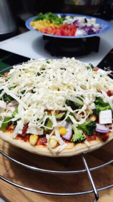 Loaded Vegetarian Pizza: A Crispy, Cheesy Delight - Plattershare - Recipes, food stories and food lovers Fresh veggie pizza topped with cheese, broccoli, corn, and diced vegetables on a crispy crust.