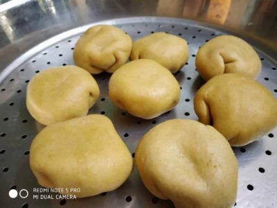 Steamed Baati Chokha: A Flavorful and Healthy Twist on a Classic Bihari Dish - Plattershare - Recipes, food stories and food lovers Soft, uncooked dough balls on a steaming tray ready for baking or steaming.