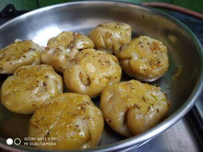 Steamed Baati Chokha: A Flavorful and Healthy Twist on a Classic Bihari Dish - Plattershare - Recipes, food stories and food lovers Steamed momos with spicy seasoning, served on a stainless steel plate. Perfect for food lovers and homemade delights.
