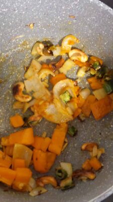Flavorful Quinoa Bowl with Roasted Vegetables and Tomato Cashew Sauce - Plattershare - Recipes, food stories and food lovers Sautéed mixed vegetables in a gray non-stick pan, cooked with spices and oil.