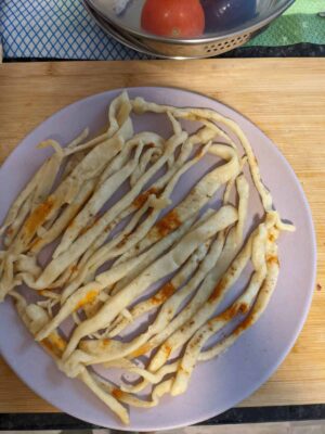 Healthy Chicken & Veggie Paratha Noodles - Plattershare - Recipes, food stories and food lovers Crispy fried noodles on a pink plate with a wooden cutting board backdrop.