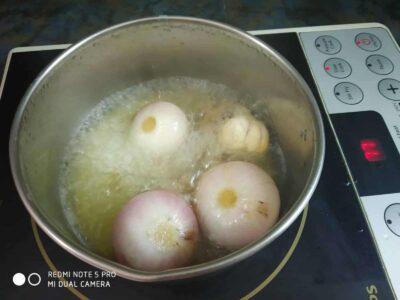 Authentic Bengali Chicken Rezala: A Rich and Flavorful Mughlai Dish - Plattershare - Recipes, food stories and food lovers Boiling onions in a stainless steel pot on an induction stove.