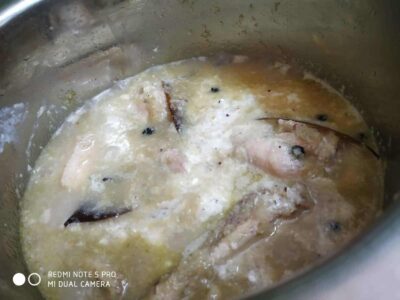 Authentic Bengali Chicken Rezala: A Rich and Flavorful Mughlai Dish - Plattershare - Recipes, food stories and food lovers Boiling fish curry with spices and coconut milk in a stainless steel pot.