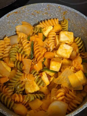 Vibrant Tricolor Pasta with Crispy Fried Paneer - Plattershare - Recipes, food stories and food lovers Colorful vegetable pasta with paneer in a skillet, garnished with herbs. Delicious, healthy meal option for food lovers.