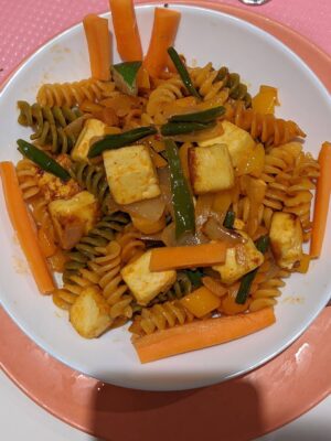 Vibrant Tricolor Pasta with Crispy Fried Paneer - Plattershare - Recipes, food stories and food lovers Savory vegetable pasta with tofu, carrots, and green beans on a white plate.
