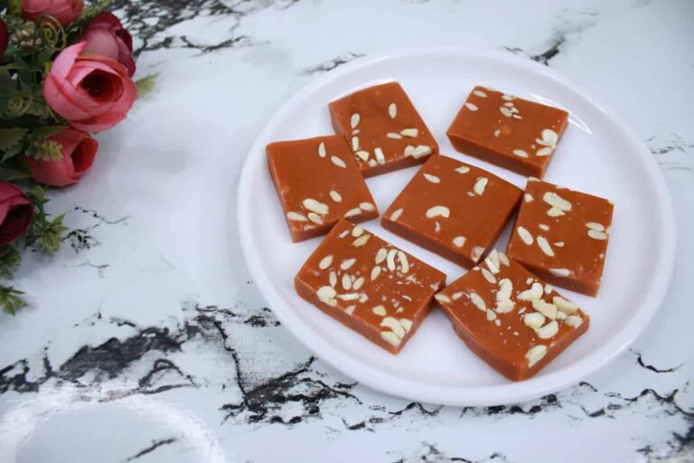 5-Minute Chocolate Khoya Barfi: Easy Indian Sweet Recipe - Plattershare - Recipes, food stories and food lovers Rich caramel fudge with almond slices arranged on a white plate. Perfect for sweet cravings and desserts.