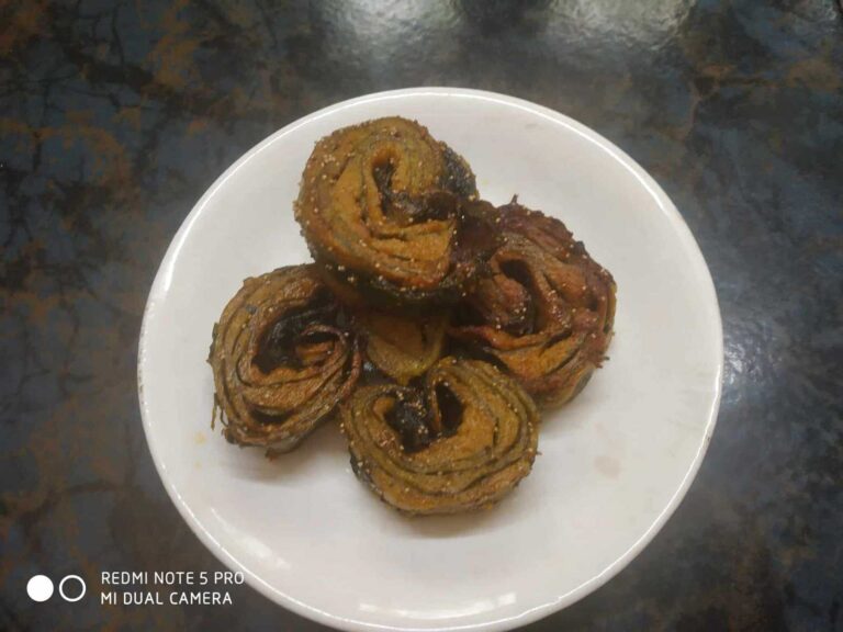 Crispy Taro Leaf Rolls with Spiced Pumpkin Filling - Plattershare - Recipes, food stories and food lovers Sweet and spicy Indian-style fried rolls on a white plate, ready to serve.