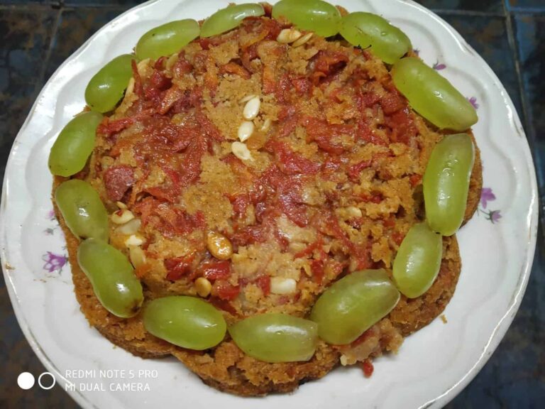 Nutritious Phalahari Baked Treat: A Delicious Fasting Recipe - Plattershare - Recipes, food stories and food lovers Creamy tomato snack garnished with grapes and nuts on a white plate.