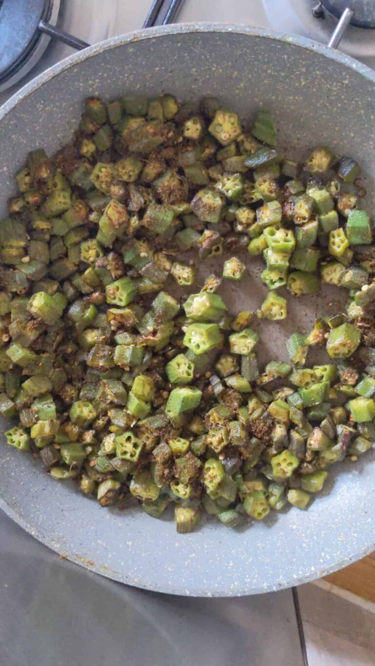 Simple Okra Fry Recipe: A Delicious Indian Side Dish - Plattershare - Recipes, food stories and food lovers Raw okra being cooked in a non-stick pan, ready for a traditional Indian dish.