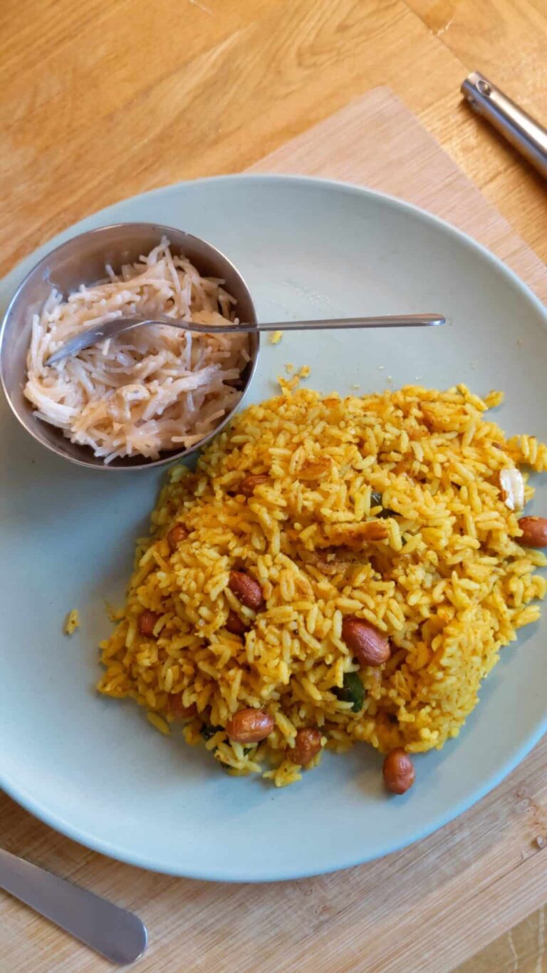 Spicy Carrot & Tomato Tamarind Rice Recipe - Plattershare - Recipes, food stories and food lovers Creamy peanut rice with shredded coconut side dish on a blue plate at a restaurant.