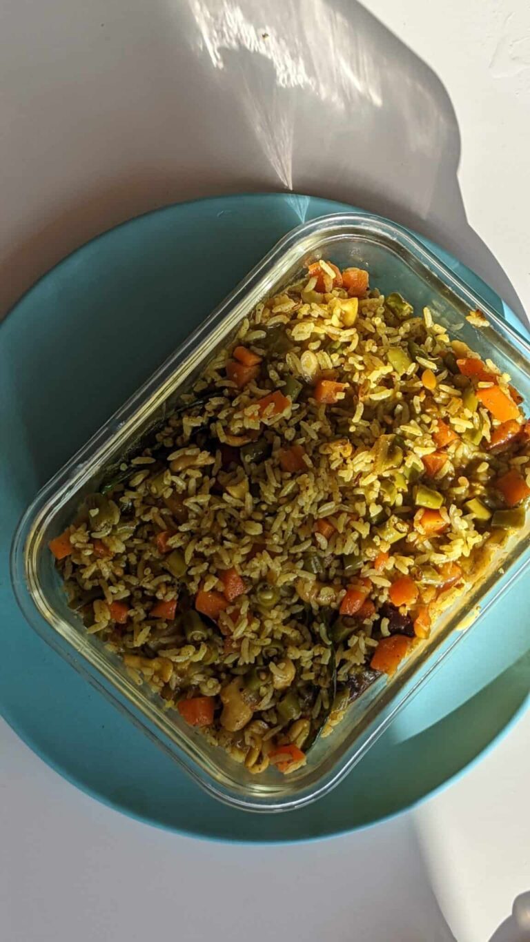 Healthy South Indian Vegetable Fried Rice Recipe - Plattershare - Recipes, food stories and food lovers Steamed vegetable fried rice in a glass container on a blue plate.