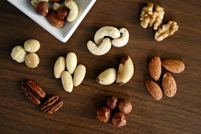 Different types of nuts displayed on a brown table