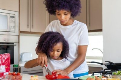 Easy and Creative Freezer Meals for a Smooth Move (Great for Families!) - A little girl cutting vegetables with her mom.