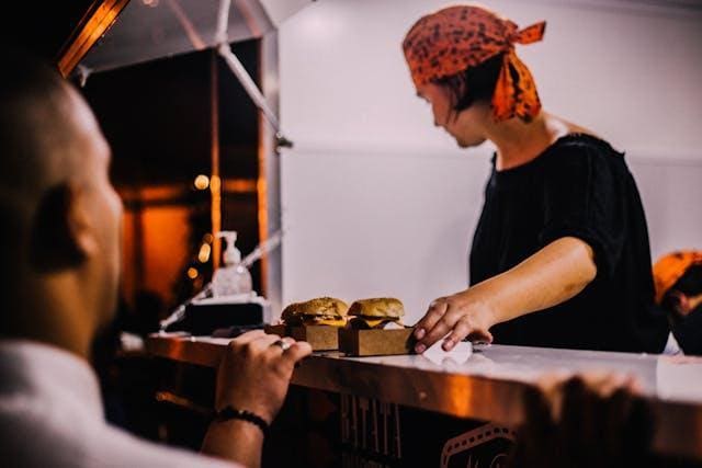 How to Organize a Mobile Kitchen for Food Truck Owners - Plattershare - Recipes, food stories and food lovers How to Organize a Mobile Kitchen for Food Truck Owners - A woman wearing a scarf on her head giving food to a man