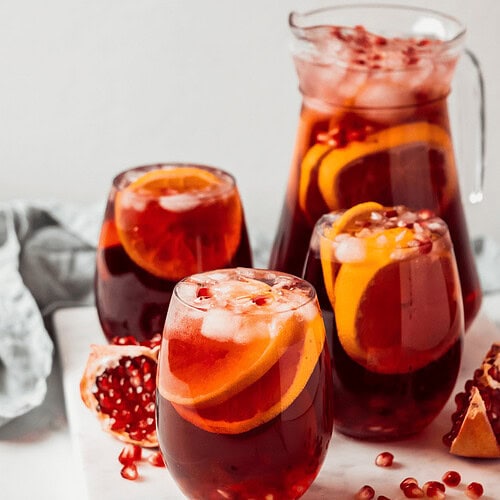 Raise a Glass Without the Buzz: Best Mocktails and Non-Alcoholic Drinks for Any Occasion - Plattershare - Recipes, food stories and food lovers Bright pomegranate and orange infused drink served with ice cubes in glassware and pitcher, refreshing summer beverage.