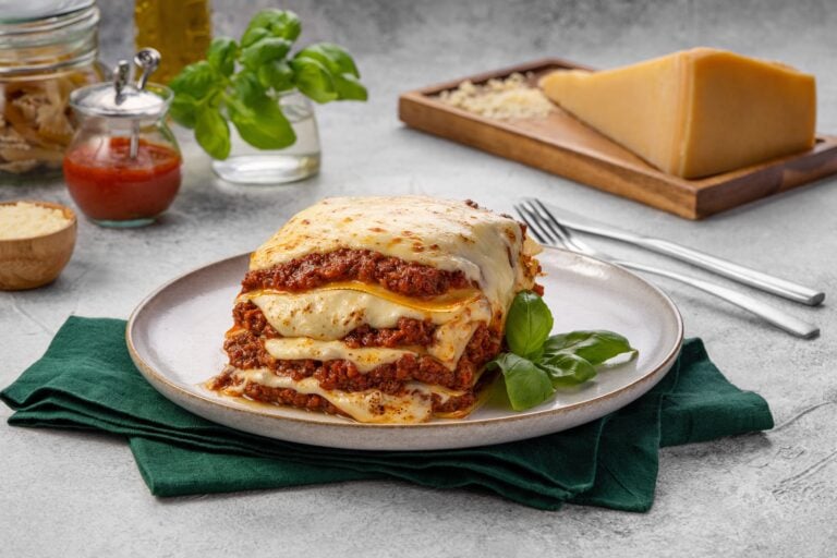IL Forno Lasagna - Plattershare - Recipes, food stories and food lovers Delicious homemade lasagna layered with cheese, rich beef sauce, and herbs served on a white plate.