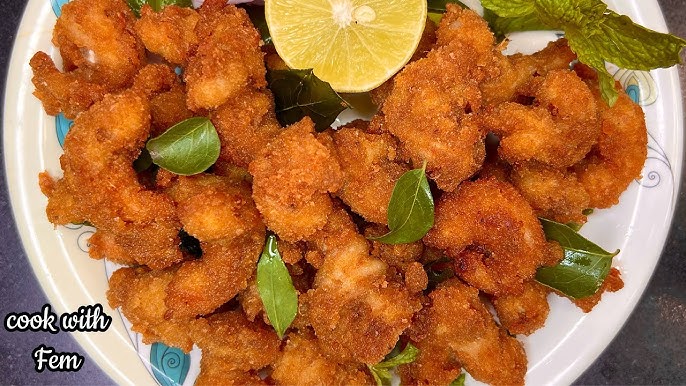 Sheet-Pan Honey Garlic Shrimp - Plattershare - Recipes, food stories and food lovers Crispy fried chicken bites garnished with lime and mint leaves on a white plate.