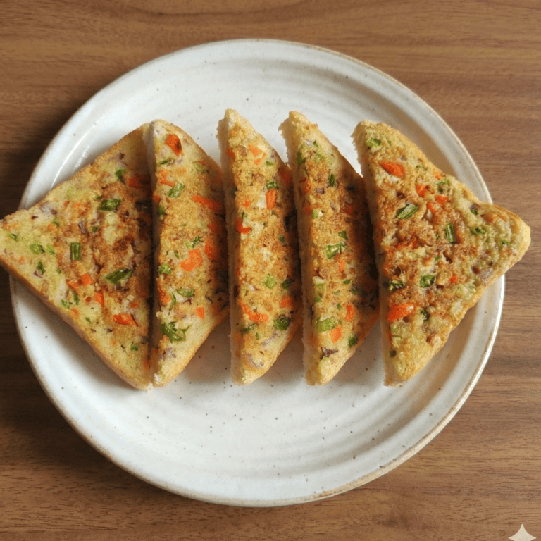 Vegetable Rava Toast (Tawa, No Butter) - Plattershare - Recipes, food stories and food lovers Colorful mixed vegetable bread cut into slices on a white plate, ready to serve.