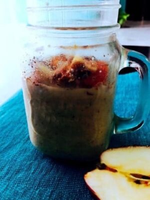 Healthy Apple Cinnamon Oats Pudding in a glass jar with fresh apple slices.