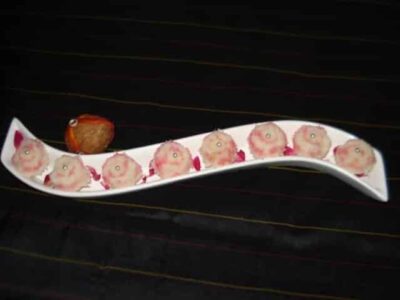 Delicious Rosy Coconut Sandesh Coins arranged on a white platter. A refreshing twist on a Bengali cl.