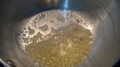 Creamy saffron risotto cooking with mushrooms and barley in a pot.
