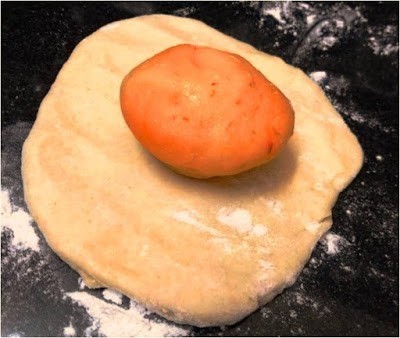 Raw dough with a spicy Schezwan flavored filling for paratha preparation.