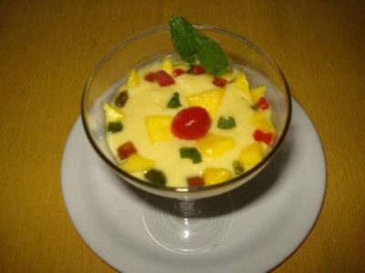Delicious Mango Paneer Pudding served in a glass, garnished with mint and colorful toppings, perfect.