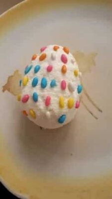 Colorful paneer Easter egg with sprinkles and chocolate-coconut filling.
