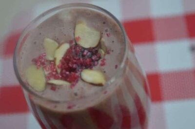Fruit and nut smoothie with fresh ingredients and toppings.