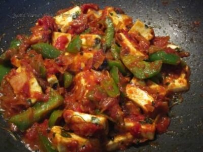 Delicious restaurant-style Indian paneer cooked with spices and vegetables on a tawa.
