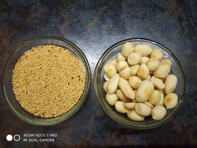 Yellow mustard seeds and peeled garlic cloves in glass bowls on a dark countertop.