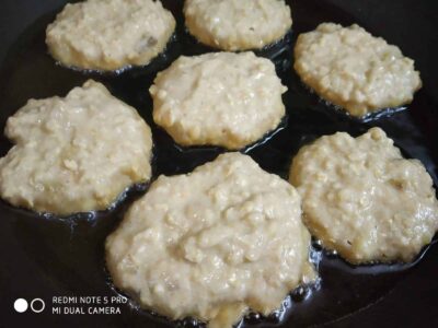 Cold, uncooked banana fritters sizzling in hot oil, ready to be fried to golden perfection.