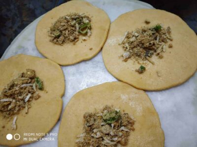 Soft, uncooked stuffed flatbreads with spiced fillings ready for cooking.