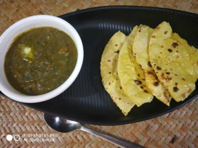 Spicy Indian dal with crispy flatbread served on a black plate, ideal for authentic Indian cuisine lovers.