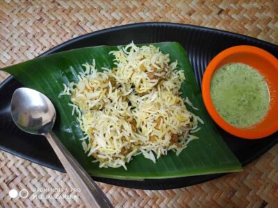 Cheese and rice dish served on a banana leaf with chutney on the side.