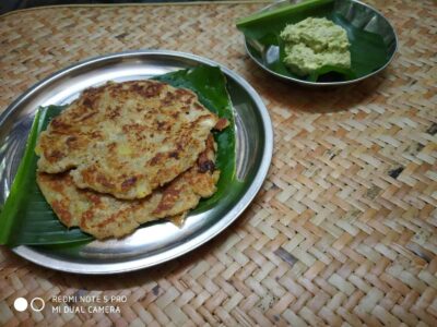 Crispy Indian roadside potato pancakes served on a banana leaf with green chutney.