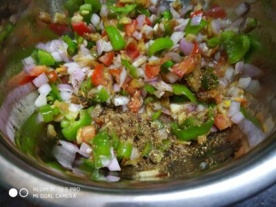 Chopped vegetables with spices in a stainless steel bowl, ready for cooking or salad.