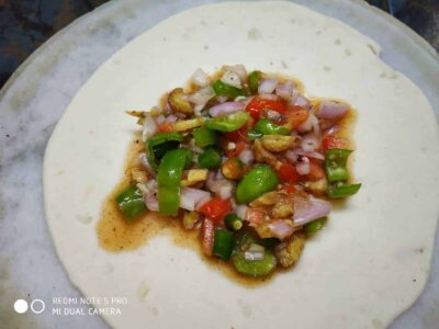 Fresh vegetable stuffing on a layered dough for making savory Indian snack.